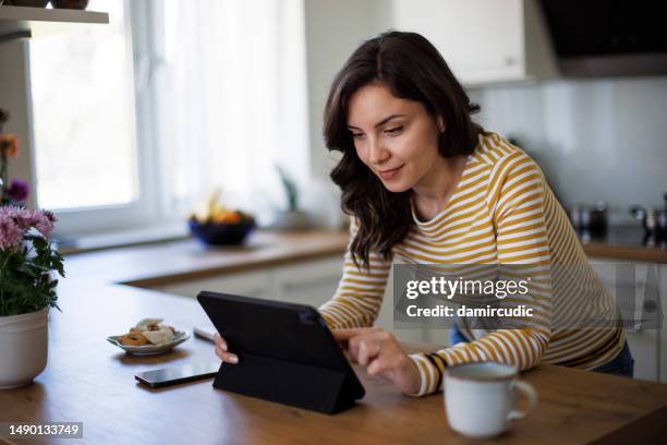 young woman using digital tablet at home - online search stock pictures, royalty-free photos & images