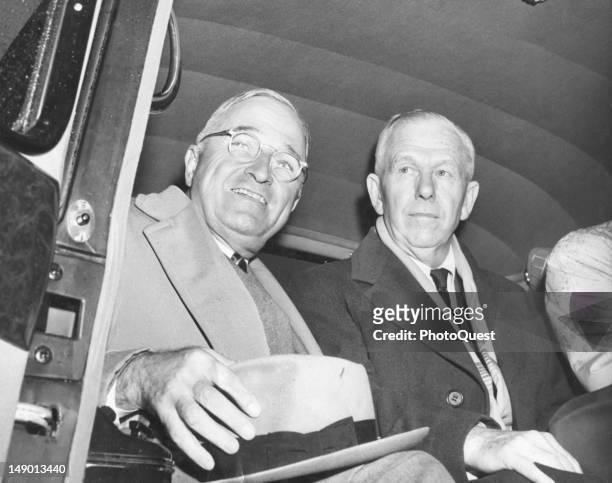 American politician US President Harry S. Truman smiles as he sits in a car with Secretary of State George C. Marshall , November 22, 1948.