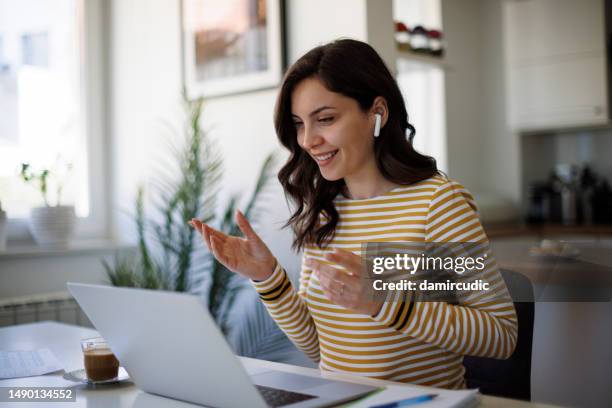 young smiling woman with bluetooth headphones having video call at home - virtual reality classroom stock pictures, royalty-free photos & images