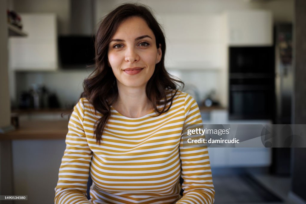 Portrait of smiling confident young woman at home