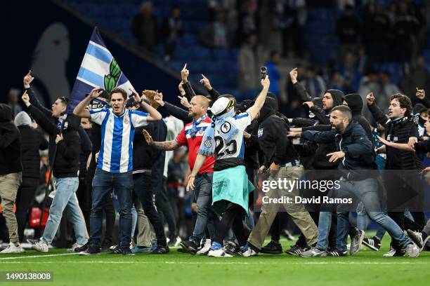 Fans of RCD Espanyol are seen on the pitch after the LaLiga Santander match between RCD Espanyol and FC Barcelona at RCDE Stadium on May 14, 2023 in...