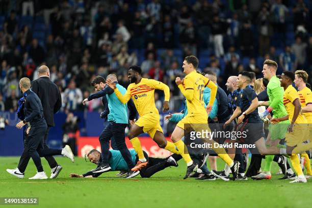 Players and staff of FC Barcelona attempt to leave the pitch as fans of RCD Espanyol attempt to pitch invade after the LaLiga Santander match between...