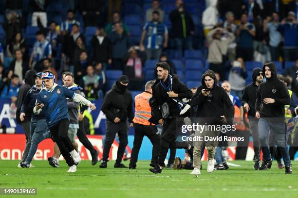 Fans of RCD Espanyol are seen on the pitch after the LaLiga Santander match between RCD Espanyol and FC Barcelona at RCDE Stadium on May 14, 2023 in...
