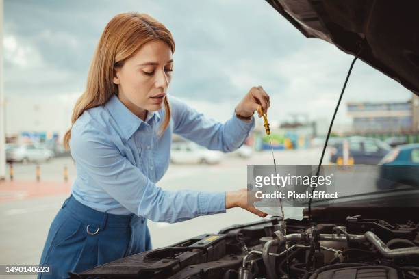 woman checking her car oil - check engine stock pictures, royalty-free photos & images
