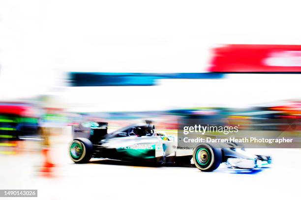 British Mercedes-AMG Formula One racing team racing driver Lewis Hamilton driving his F1 W05 car at speed in front of a multi coloured background in...