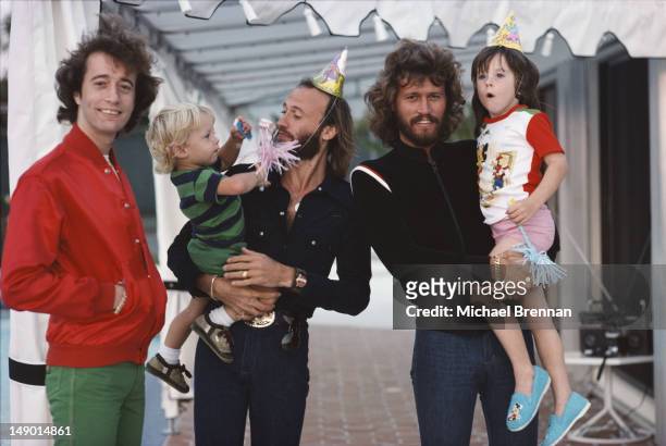 Bee Gees Robin, Maurice and Barry Gibb with their children in Miami, Florida, March 1978.