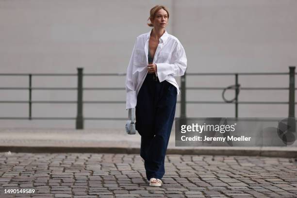 Nadine Berneis seen wearing a Prada denim black logo bra, Diesel 1DR mini denim baby blue handbag, Closed wide leg, dark blue denim belt pants, black...