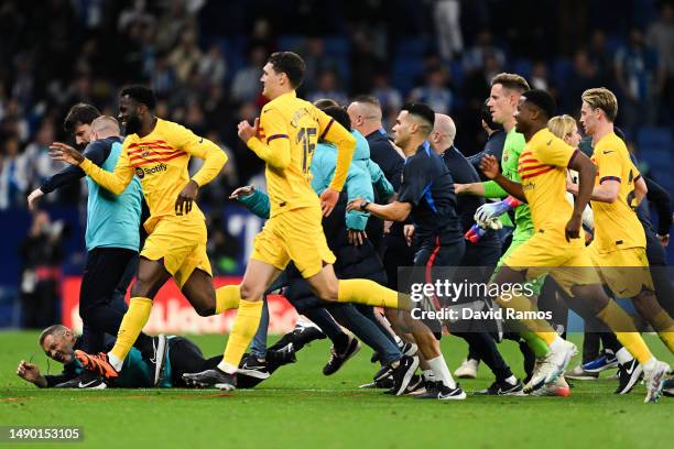 Players and staff of FC Barcelona attempt to leave the pitch as fans of RCD Espanyol attempt to pitch invade after the LaLiga Santander match between...