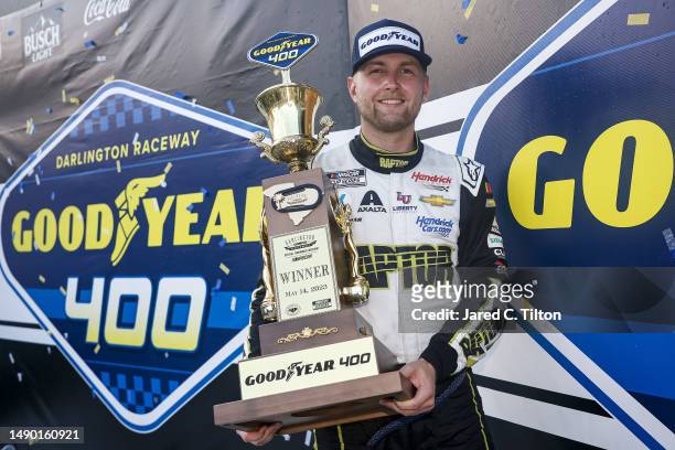 William Byron, driver of the Axalta Throwback Chevrolet, celebrates with the trophy after winning the NASCAR Cup Series Goodyear 400 at Darlington...