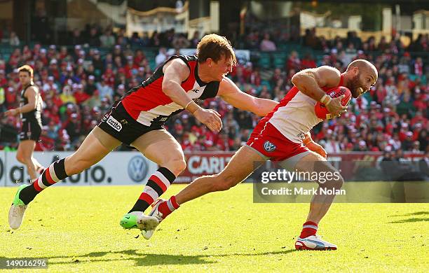 Brendon Goddard of the Saints tackles Jarrad McVeigh of the Swans during the round 17 AFL match between the Sydney Swans and the St Kilda Saints at...