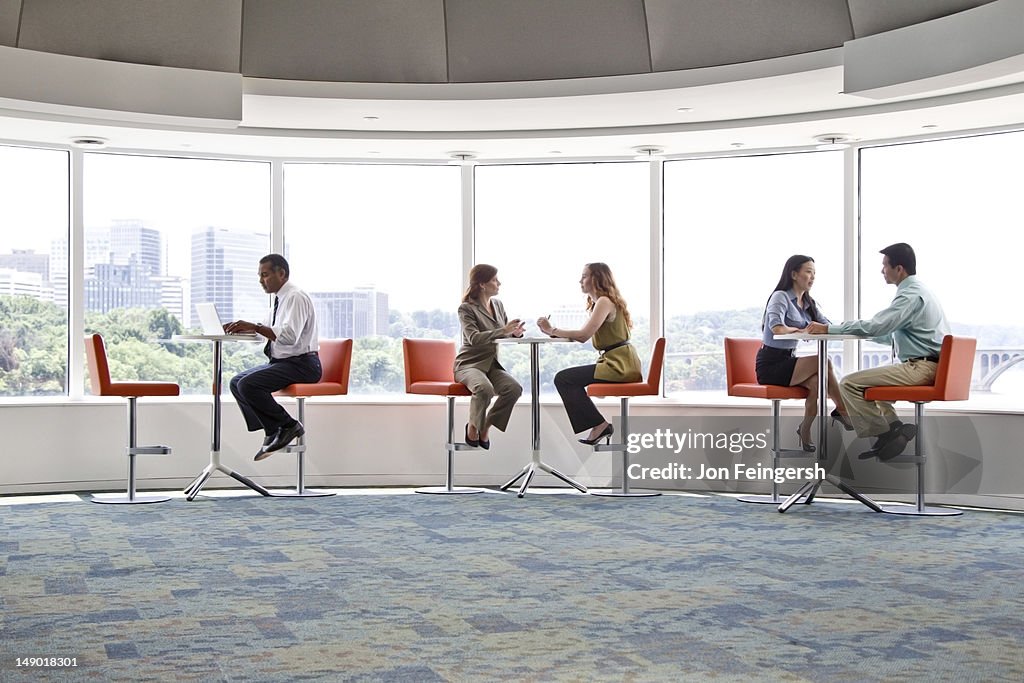 Business people at high tables by windows