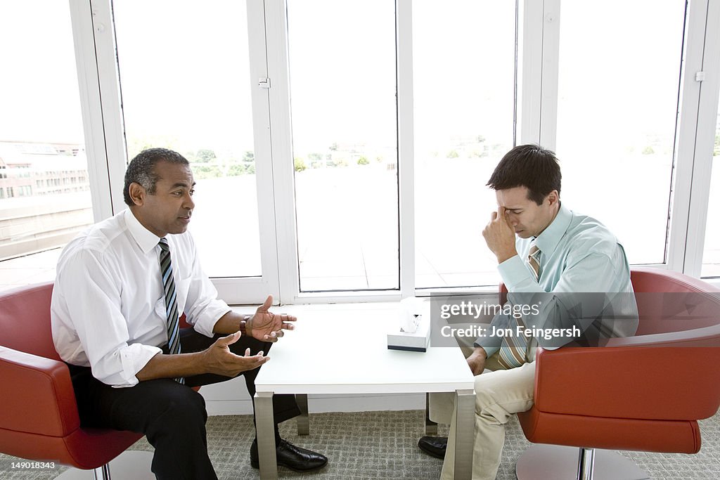 Two businessmen working together by windows