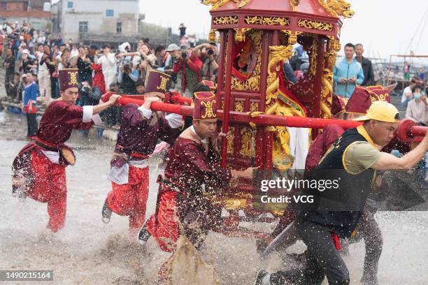 Pilgrims carry a sedan chair holding a statue of the sea goddess Mazu during a worshiping ceremony on May 14, 2023 in Ningde, Fujian Province of...