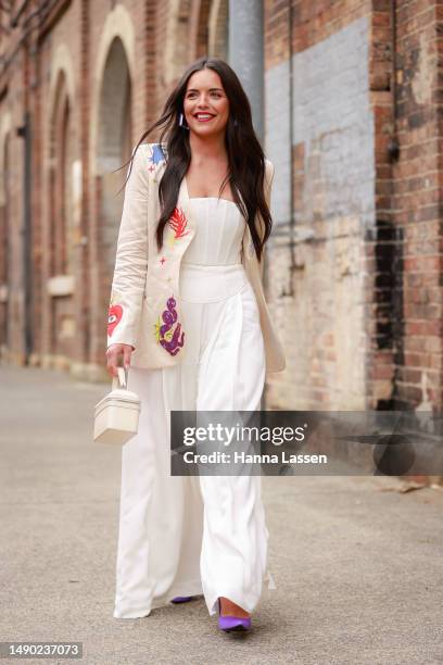 Olympia Valance wearing Alemais white suit and Bulgari white leather bag at Afterpay Australian Fashion Week 2023 at Carriageworks on May 15, 2023 in...