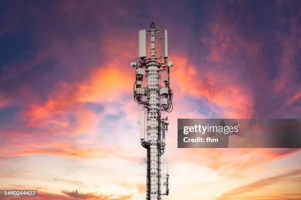 mobile phone antenna station at sunset - tour de télécommunication photos et images de collection