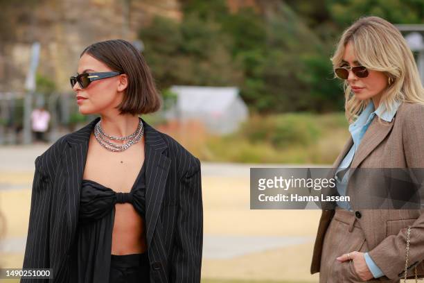 Victoria Burns wearing Bondi Born crop top and pants and Atoir blazer and Emily Gurr wearing Scanlan Theodore suite and Louis Vuitton clutch at...
