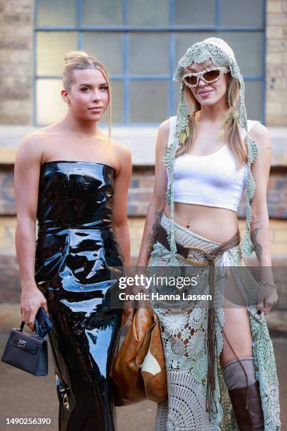 Mitch Greer wearing black patent dress and Imogen Anthony wearing Olivia Rubens outfit at Afterpay Australian Fashion Week 2023 at Carriageworks on...