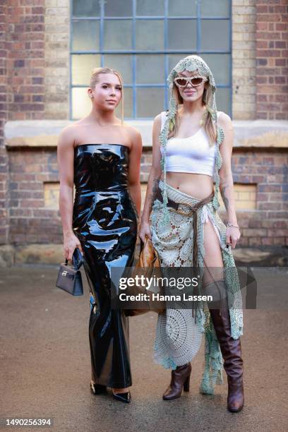 Mitch Greer wearing black patent dress and Imogen Anthony wearing Olivia Rubens outfit at Afterpay Australian Fashion Week 2023 at Carriageworks on...