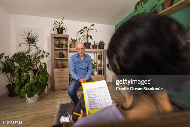 home psychotherapy session - doctor with male patient reading notes stock pictures, royalty-free photos & images