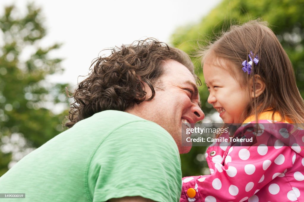 Father and daughter smiling while playing