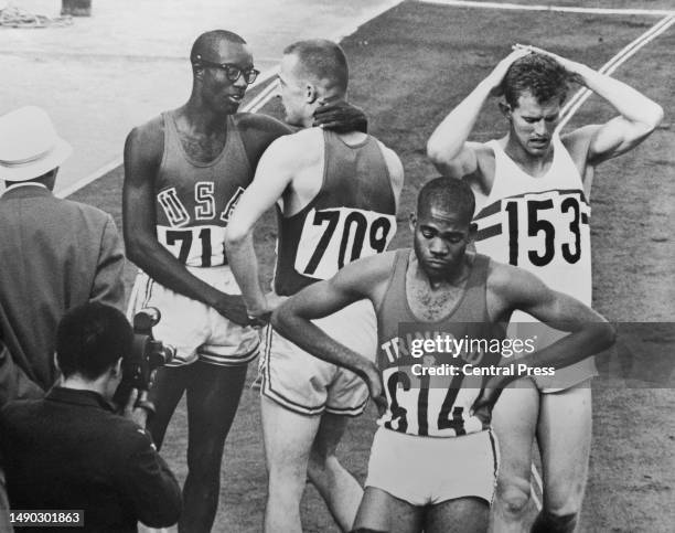 Ulis Williams and Mike Larrabee of the USA; Edwin Skinner of Trinidad and Tobago; Robbie Brightwell of Great Britain after completing the Men's 400...