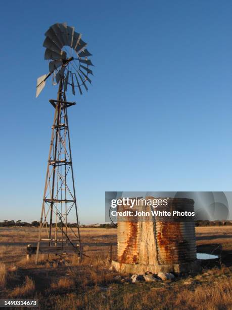 rusty water tank and windmill. - outback windmill stock pictures, royalty-free photos & images