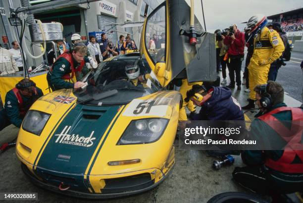 Co driver Justin Bell looks on as Andy Wallace from Great Britain driver the Harrods Mach One Racing McLaren F1 GTR BMW V12 is strapped into the car...