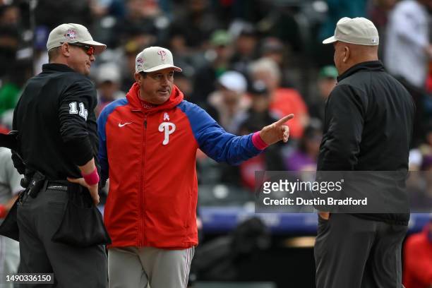 Umpire Ryan Wills and umpire Jeff Nelson have a word with Rob Thomson of the Philadelphia Phillies in the sixth ininng of a game against the Colorado...