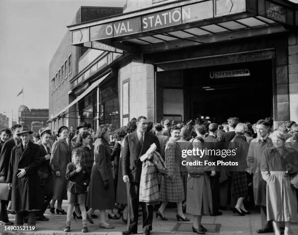 Crowd of people queuing outside Oval London Underground Station, at the junction of Camberwell New Road, Kennington Park Road, Harleyford Street, and...
