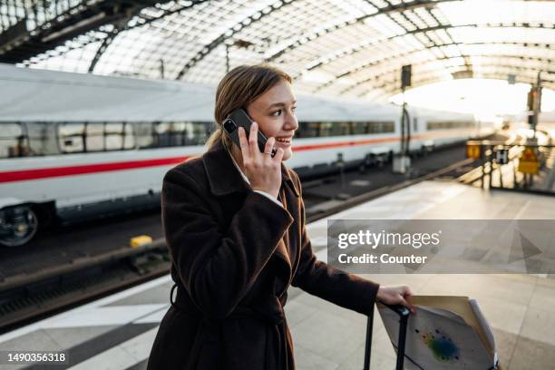 business traveler on phone call in train station - bahnreisender stock-fotos und bilder