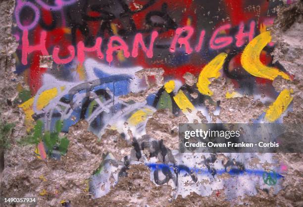 "Human Rights" and other graffiti are written on the Berlin Wall at the time of its opening in late 1989, at the end of the separation of East and...