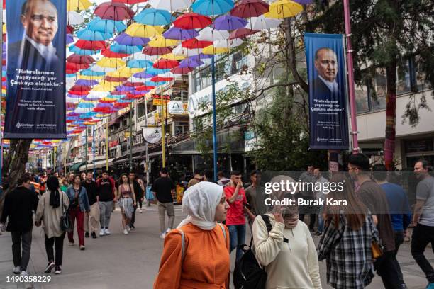 People walk past under the posters of Mustafa Kemal Ataturk, founder of modern Turkey on May 15, 2023 in Ankara, Turkey. The country is holding its...