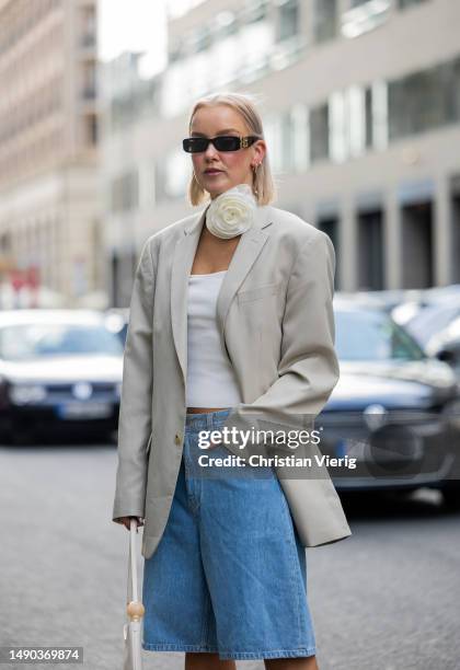 Tina Haase wears Carhartt baggy Bermuda shorts, vintage oversized beige blazer, flower choker, Jacquemus Bisou Baguette Bag, vintage Guido Sgariglia...