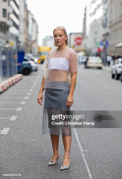 Tina Haase wears Zara transparent white organza top & grey midi skirt, vintage Guido Sgariglia mules, Jacquemus Bisou Baguette Bag on May 15, 2023 in...