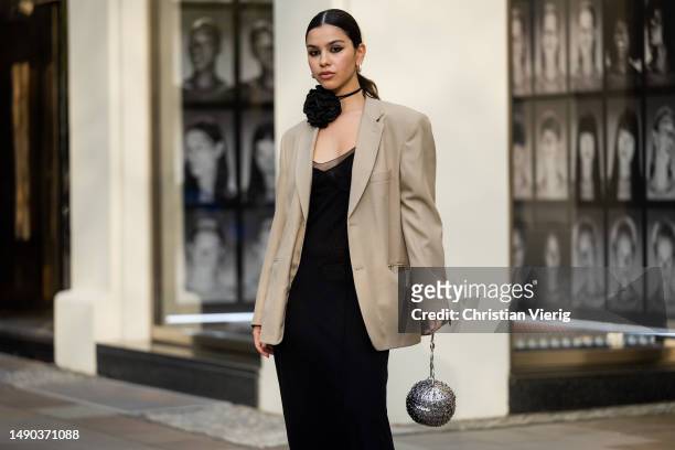 Bella Emar wears black dress, beige blazer, Paco Rabanne bag, heeled sandals, flower choker on May 15, 2023 in Berlin, Germany.