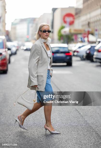 Tina Haase wears Carhartt baggy Bermuda shorts, vintage oversized beige blazer, flower choker, Jacquemus Bisou Baguette Bag, vintage Guido Sgariglia...