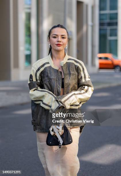 Amelie Stanescu wears brown beige biker leather jacket Vintage, sheer midi skirt Marni, pointed toe boots by Roberto Cavalli, baguette nylon bag by...