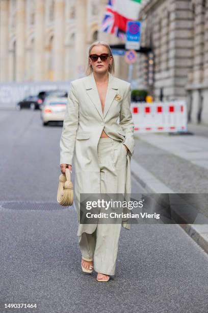 Tina Haase wears Nakd beige long blazer & low waist pants , Loewe anagram pin, Zara sandals, Celine sunglasses, beige Bottega Veneta bag on May 15,...