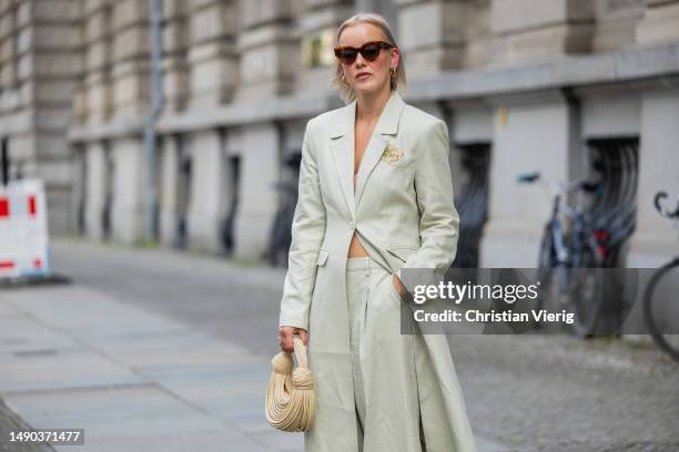 Tina Haase wears Nakd beige long blazer & low waist pants , Loewe anagram pin, Zara sandals, Celine sunglasses, beige Bottega Veneta bag on May 15,...