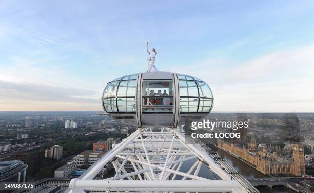 In this handout image provided by LOCOG, Amelia Hempleman-Adams poses with the Olympic Flame on top of a London Eye pod during Day 65 of the London...