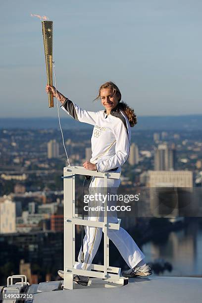 In this handout image provided by LOCOG, Amelia Hempleman-Adams poses with the Olympic Flame on top of a London Eye pod during Day 65 of the London...