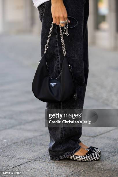 Jacqueline Zelwis wears white ONWEEKENDS T-Shirt, dark Calvin Klein jeans, Pretty Ballerinas shoes, Prada bag, Marc Jacobs sunglasses on May 15, 2023...