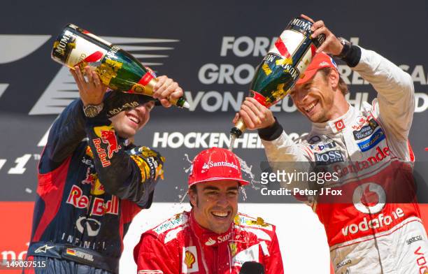 Fernando Alonso of Spain and Ferrari celebrates his win with Sebastian Vettel of Red Bull and Germany and Jenson Button of Great Britain and McLaren...