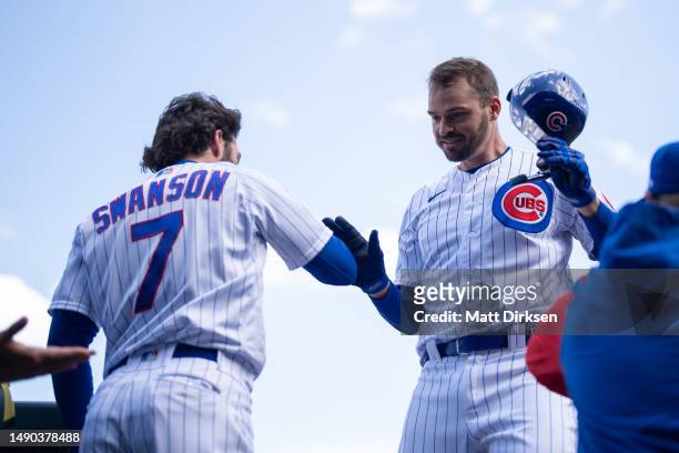 Trey Mancini of the Chicago Cubs celebrates with Dansby Swanson in a game against the Los Angeles Dodgers at Wrigley Field on April 21, 2023 in...
