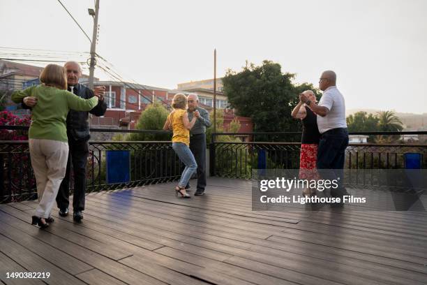 multiple pairs of senior couples dance together on a rooftop in valparaíso, chile - free pictures ballroom dancing stock pictures, royalty-free photos & images