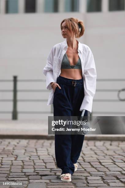 Nadine Berneis seen wearing a Prada denim black logo bra, Diesel 1DR mini denim baby blue handbag, Closed wide leg, dark blue denim belt pants, black...