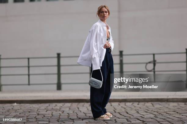 Nadine Berneis seen wearing a Prada denim black logo bra, Diesel 1DR mini denim baby blue handbag, Closed wide leg, dark blue denim belt pants, black...