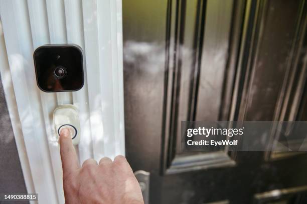 hand pressing smart home technology video doorbell. - timbre de la puerta fotografías e imágenes de stock