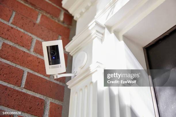 a outdoor home security smart home technology camera looking directly into camera with recording light on. - camera de surveillance photos et images de collection