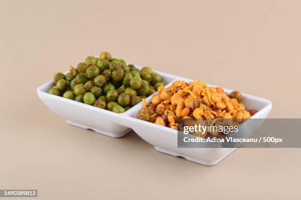 indian snack mixture and spiced fried green peas chatpata matar in white plate,romania - matar stock pictures, royalty-free photos & images